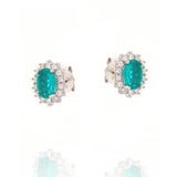 Pair of silver-toned stud earrings, each with an oval green central stone surrounded by a halo of clear round stones.