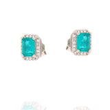 Pair of silver-toned square stud earrings with a central emerald-cut teal stone surrounded by a halo of small clear stones.
