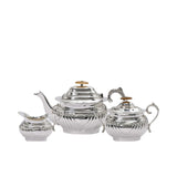 Royal Family 3-piece silver-plated tea set featuring a teapot, sugar bowl, and creamer with fluted bases, ornate silver handles, and light wood lid knobs on a white background