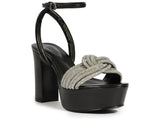 Side view of a Schutz Keefa platform sandal in metallic gold leather with a sparkling crystal knot toe strap and high block heel.