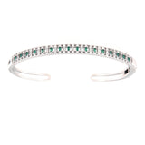 Silver-toned open bangle with a top row of alternating clear and green baguette stones.