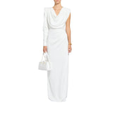 A woman modeling a long white draped dress with a deep V-neckline and sleeveless cap sleeves, holding a matching white structured handbag against a plain white background.