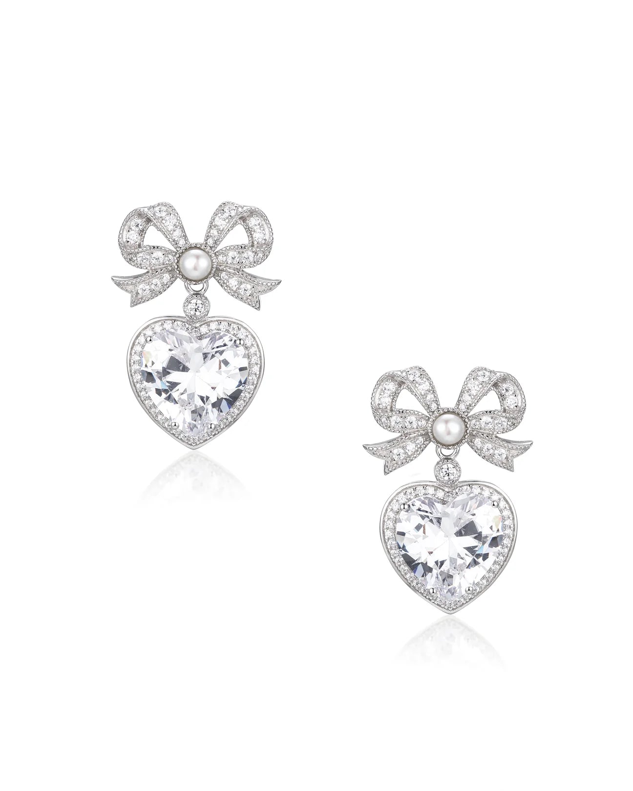 Pair of silver-toned drop earrings with crystal-studded bows, a small white pearl, and a large pink crystal heart pendant.