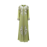 A floor-length olive green two-piece kaftan set by SHAIRA featuring a pleated inner dress and a sheer outer robe with heavy ivory floral embroidery and 3D petal details.