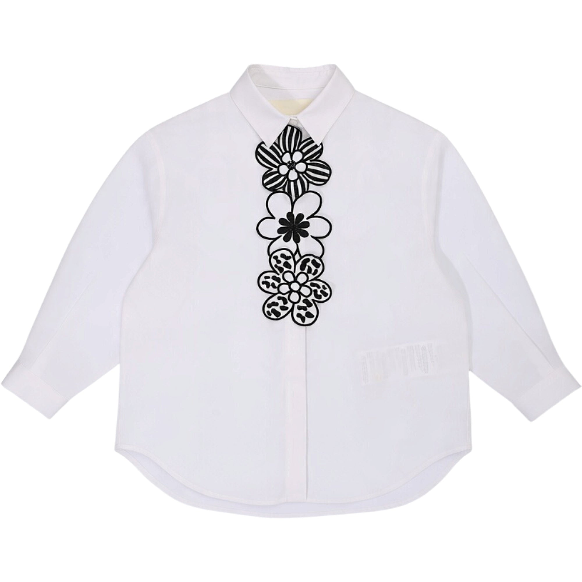 White long-sleeved collared shirt with a vertical panel of four black floral appliques on the front, featuring varied pattern