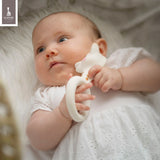 White natural rubber Sophie La Girafe ring teether with a giraffe head, pink cheeks, and brown neck spots.