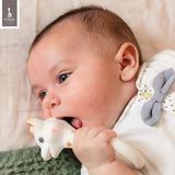 White giraffe-shaped teether with orange spots, pink cheeks, and black eyes.