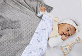 Soft blanket with one side gray minky dot fabric and the other white with gray Sophie La Girafe and star print.