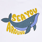Detailed macro shot of the high-quality screen print on the Stella McCartney Kids t-shirt, showing a blue whale graphic and "Sea You Around" typography.