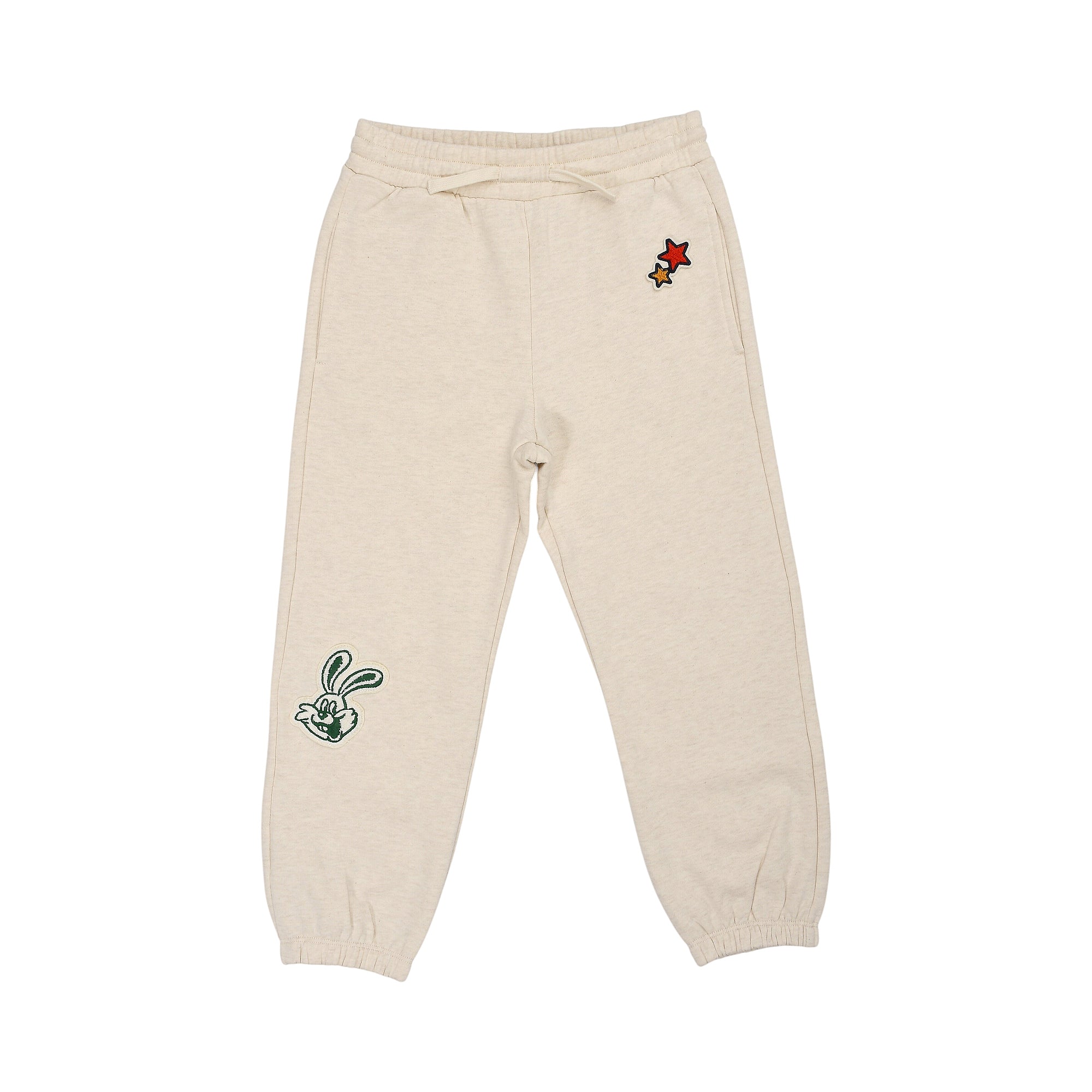 Beige jogging pants with drawstring waist, cuffed ankles. Features green embroidered rabbit on left leg, red and gold-toned s