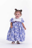 Baby girl's dress with a white bodice, blue and white striped skirt, white lace overlay, and a blue, red, and white ribbon bo
