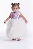 Off-white sleeveless dress with a sequinned floral bodice in pink and blue, and a voluminous off-white ruffled skirt.