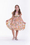 Peach short-sleeved kids' dress with yellow and orange floral and butterfly embroidery and a green ribbon belt.