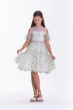 Off-white kids dress with sheer off-shoulder ruffled sleeves, sheer yoke, and vertical green and purple floral embroidery.