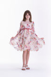 Beige kids' dress with a multi-coloured floral pattern, sheer round neckline, long ruffled sleeves, and a red velvet waist ri