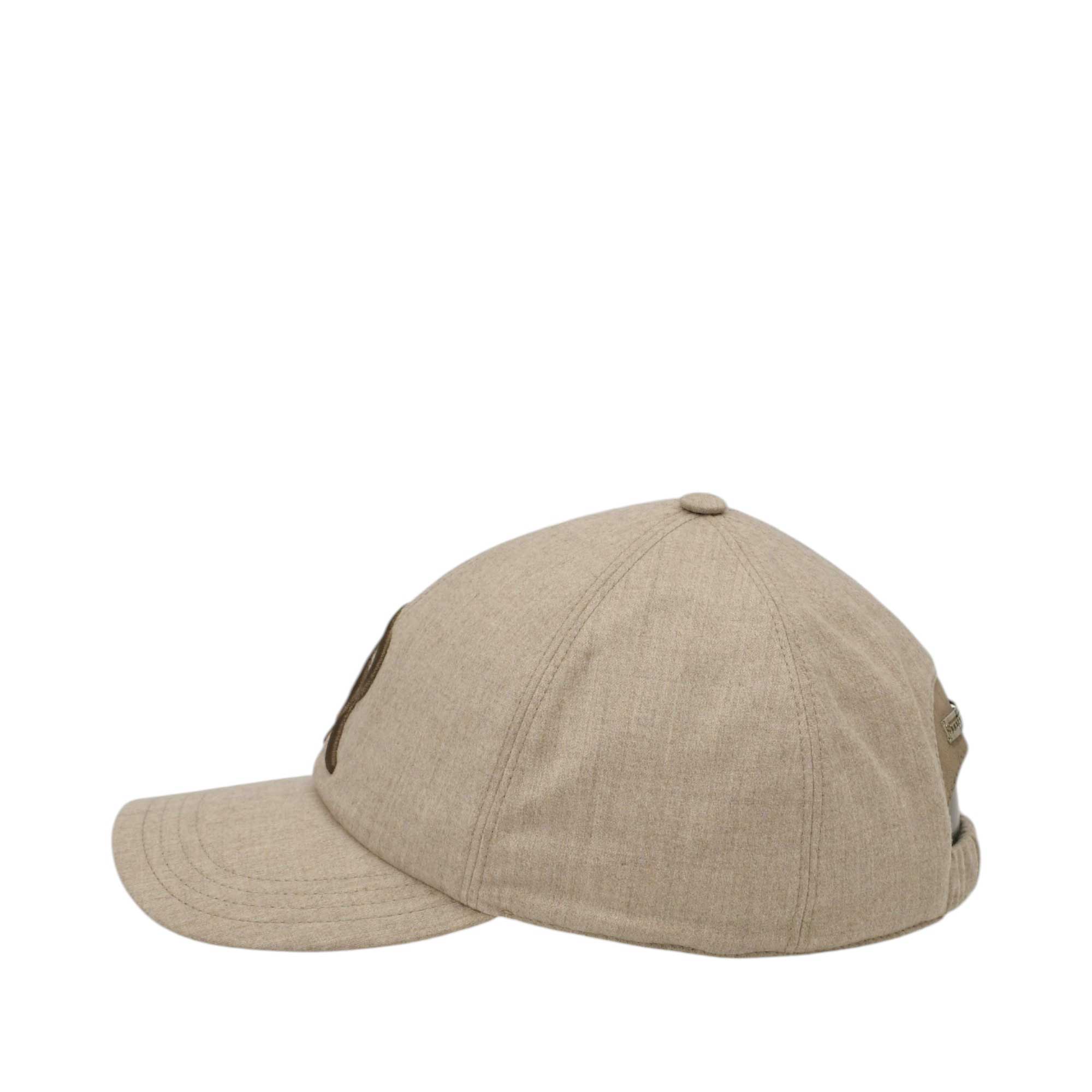 Beige baseball cap with a curved brim, dark brown embroidered logo on the side, and an adjustable back strap with a gold-tone