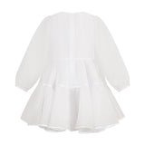 White sheer tiered dress, back view. Long voluminous sleeves with elasticated cuffs. Center back zipper and white trim on ski