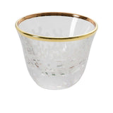 Close-up of a single crystal cup highlighting the hand-painted gold rim and white frosted botanical design.