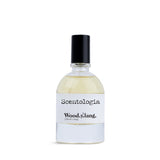 Scentologia Wood.y.lang fragrance, featuring a minimalist glass bottle with a white label and black cap, displayed alongside its artistic branded outer box.