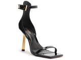 Angled view of Schutz Keefa black sandal showing the square toe, cushioned insole, and metallic gold-tone hardware.