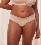Second Model front view of the Triumph Flex Smart beige high-leg Brazilian panty, showcasing the smooth neutral fabric and cheeky cut. Available Online Today