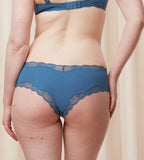 Second model back view of the Triumph Natural Spotlight blue hipster panty, showing the low-rise fit and flat lace detailing at the legs. Shop Now Online