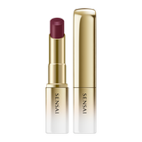 Sensai lipstick with gold casing and purple shade on a white background.