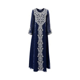 A full-length photo of a midnight blue SHAIRA jalabiya featuring elaborate silver floral embroidery down the center and on the sleeve cuffs. The dress is made of lightweight chiffon with long sleeves and a V-neckline.