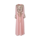 Front view of a SHAIRA PINK-colored maxi dress featuring heavy gold and silver floral beadwork on the chest, a belted waist, and long sleeves on a white background.