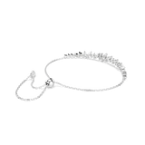 A side perspective studio shot of the Swarovski Mesmera bracelet draped on a white surface, highlighting the fluid drape of the fine chain and the curved structural alignment of the crystal bar.