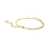 A side perspective studio shot of the Swarovski Matrix bracelet draped on a flat surface, showcasing the continuous shine of the gold-plated tennis settings and the smooth lobster clasp enclosure.