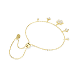 A side perspective studio shot of the Swarovski Magic bracelet, showcasing the smooth, high-shine gold-plated backings of the dangling charms and the adjustable sliding ball mechanism.