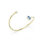 A side perspective studio shot of the Swarovski Chroma bangle tilted upwards, emphasizing the structural curve of the gold cuff and the dimensional profile of the mismatched crystal endpoints.