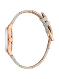 Profile perspective view of the watch, showing the slim depth of the rose gold-plated casing, the integrated crown guard mechanism, and the contoured curve of the off-white leather strap with its matching rose gold buckle.