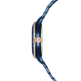 A clean side profile view of the Swarovski Octea Moon watch case, displaying the smooth blue-coated silhouette, the rose gold-tone scalloped bezel edge, and a clear crystal embedded into the setting crown.