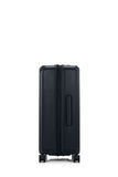Side view of the Samsonite Voypod Spinner medium in Black, showcasing its sleek, boxy hardshell design and the prominent front-access pocket panel. Find Online Today