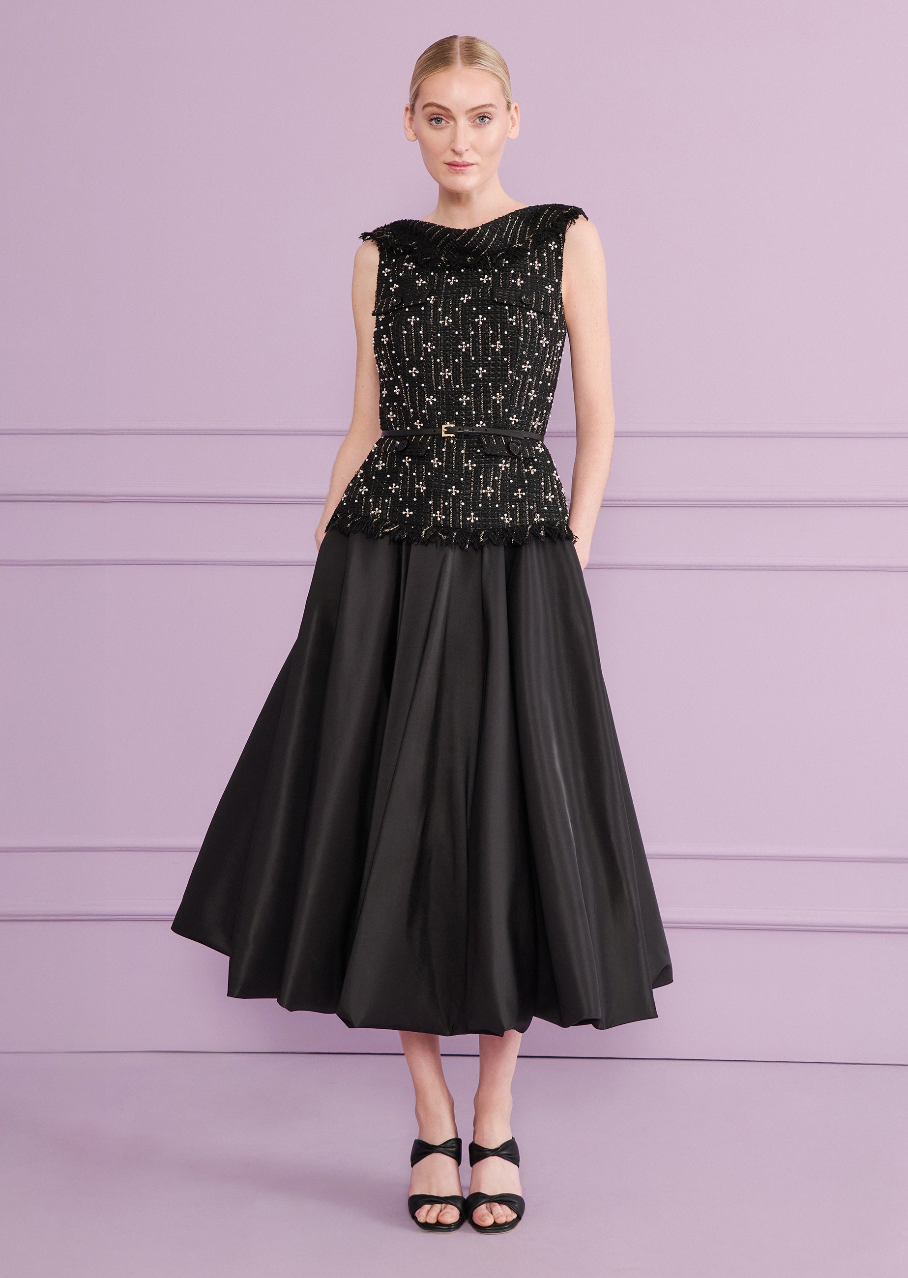 Black midi dress. Sleeveless tweed top with white beaded patterns, fringed neckline and hem. Black belt, gold-toned buckle. F