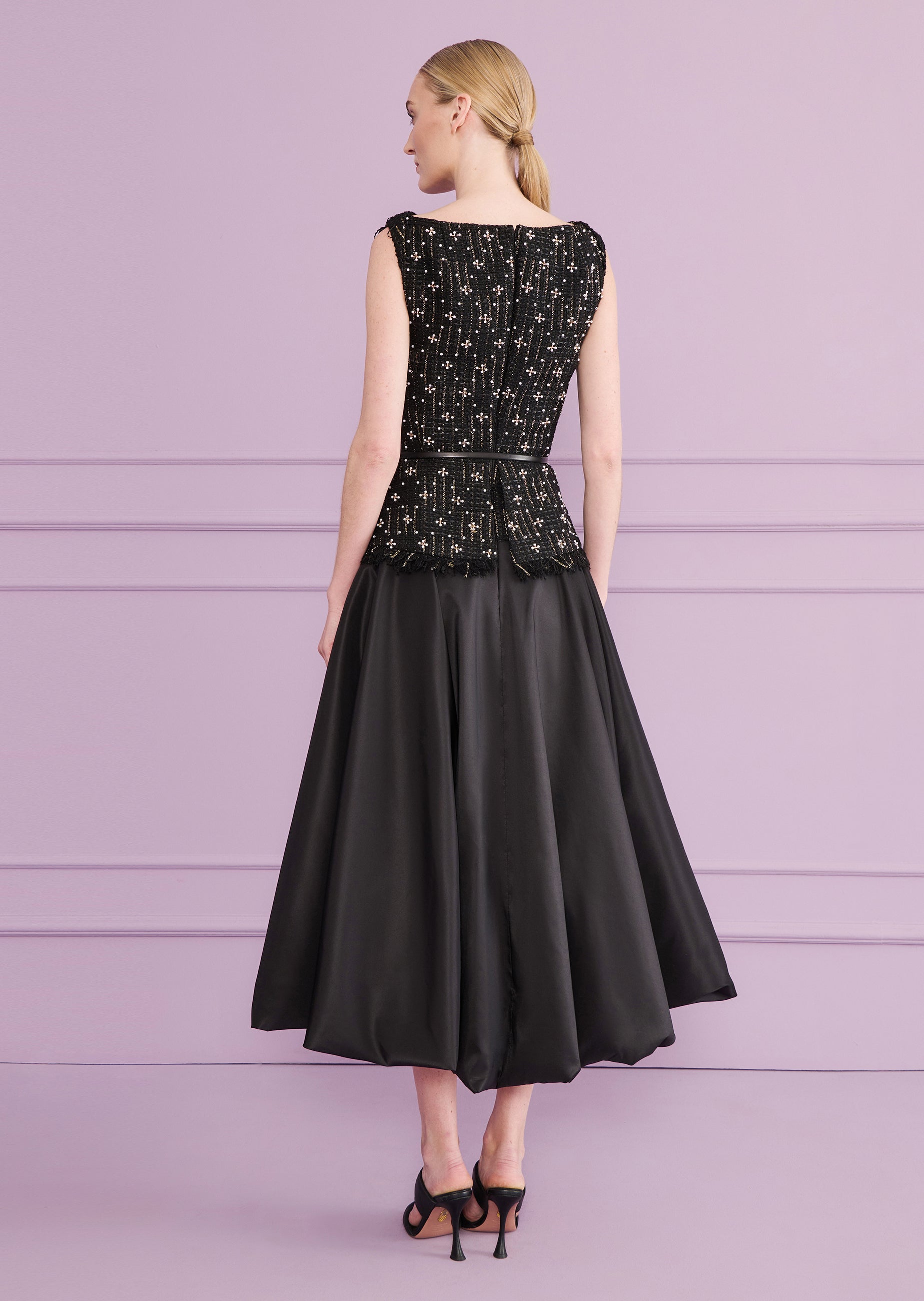 Black midi dress with a sleeveless, embellished top featuring a fringed hem and a thin belt. The voluminous skirt has a bubbl