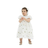 Toddler girl wearing an ivory lace dress with small blue and gold butterfly embroidery and a matching lace bonnet.