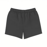 Back view of Stella McCartney Kids kids' swim shorts in solid dark grey showing the clean stitching lines and an elasticized waistband on a white background.