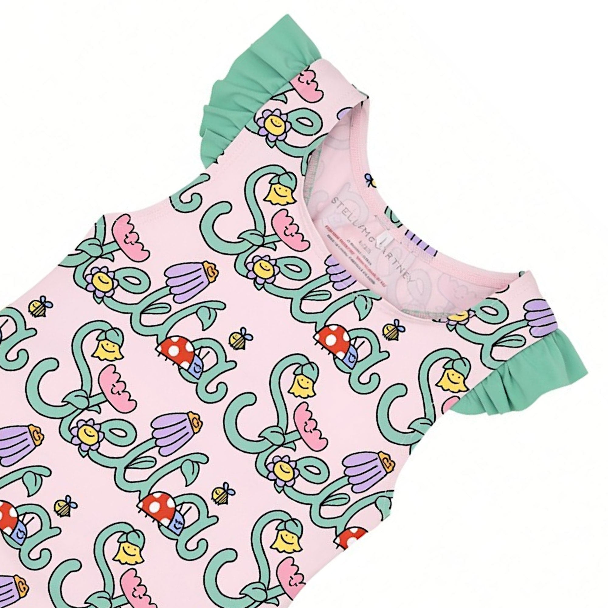 Front full-length view of a Stella McCartney Kids girls' one-piece swimsuit in pale pink, featuring a repeating garden logo print and mint green ruffled sleeves.