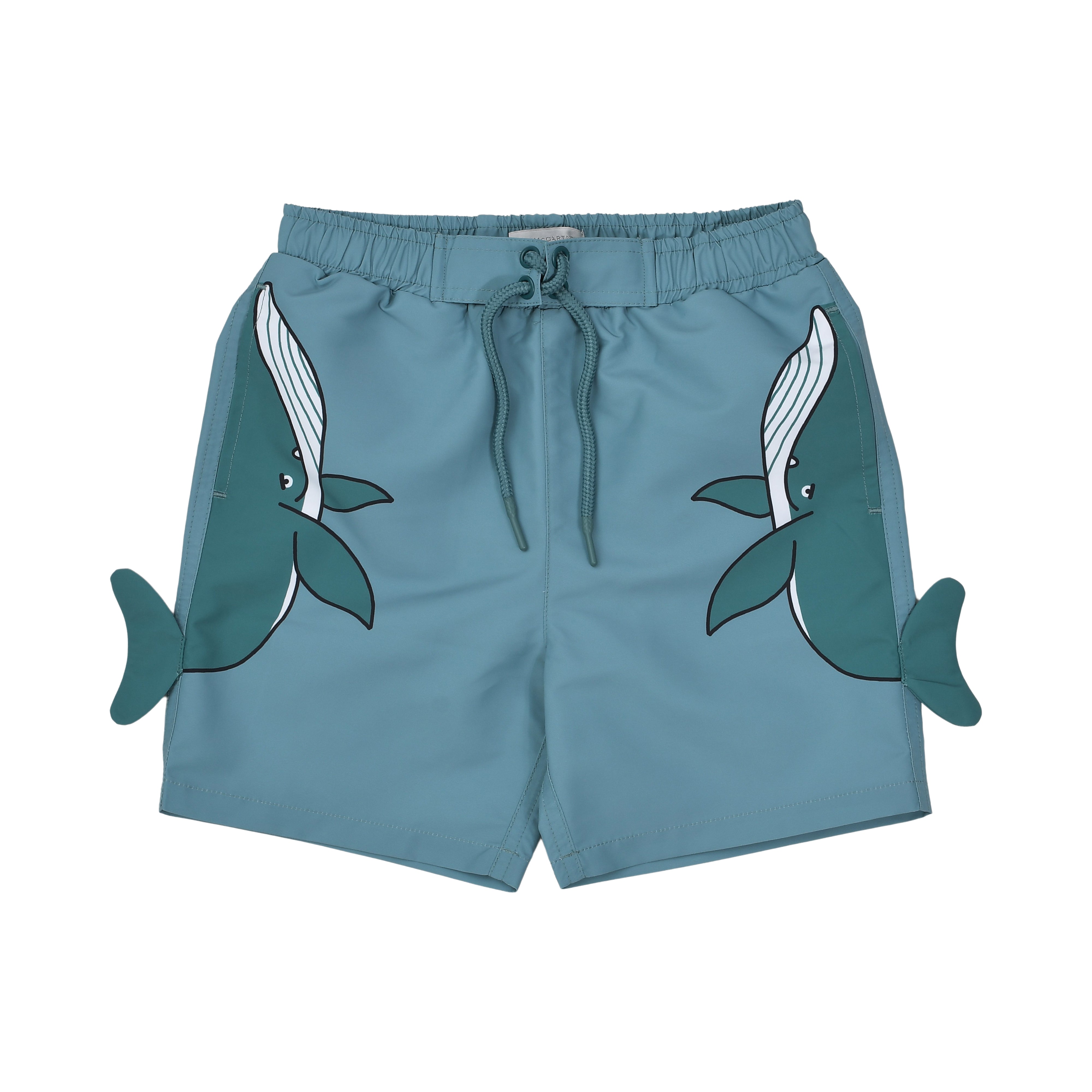 Front view of Stella McCartney Kids teal swim and play shorts featuring an elastic drawstring waist and twin whale graphics with protruding 3D side fins.