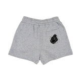 Back view of children's grey marl shorts showing a patch pocket decorated with a black hand-gesture graphic and circular brand logo.