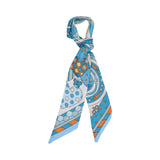 Styled view of the Muni women’s blue twilly scarf with owl, heart and geometric multicolor print. Shop Now Online