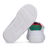 White low-cut sneakers with a textured white sole. Features a green heel tab, red trim, and blue collar lining. A white velcr
