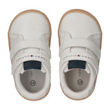 Pair of white sneakers with two velcro straps, each featuring "TOMMY HILFIGER" text and flag logo. They have light brown sole