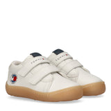 Pair of white Tommy Hilfiger Kids mid-cut sneakers with two Velcro straps, a gum rubber sole, and a side logo patch.