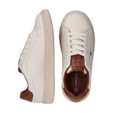 Off-white low-cut lace-up sneakers with cognac brown tongue and heel trim. Small flag logo on the side.