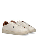 Pair of low-cut lace-up sneakers in off-white with cognac brown heel collars and tongue lining, featuring a small flag logo.