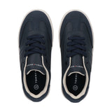 Pair of navy blue low-cut sneakers with white soles, cream collar trim, navy laces, and Tommy Hilfiger logo on the side.
